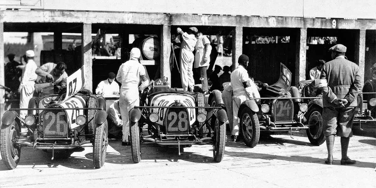 Startvorbereitungen an den Bugatti Boxen. Wertungsgruppe II über 1500-3000-ccm (roter Querstreifen auf der Motorhaube). Zur besseren Unterscheidung der Team-Mitglieder, hatte man auf der Motorhaube einen Farbstreifen aufgemalt.